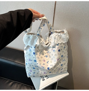 Detail of floral canvas tote bag featuring white lace trim and blue purple patterns