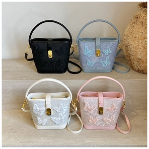 Détail de sacs seaux cartoon en quatre couleurs avec broderie et boucles dorées