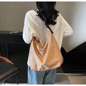 Detailed view of the large capacity tote bag featuring glossy fabric and adjustable strap