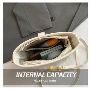 Vue intérieure d'un sac seau en cuir blanc avec plusieurs compartiments et détails dorés