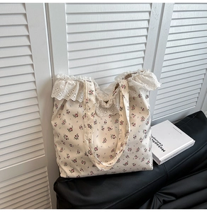 Detailed macro view of white lace ruffle and pink floral pattern on a canvas tote bag