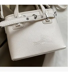 Dettaglio borsa a secchiello bianca in pelle martellata con fibbie in metallo