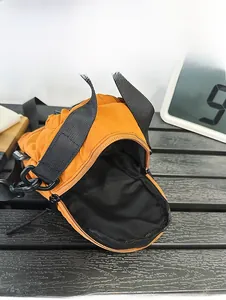 Internal capacity display of orange nylon bucket bag with black woven shoulder strap