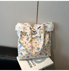 Close-up of floral tote bag with white lace trim detail on a minimalist background