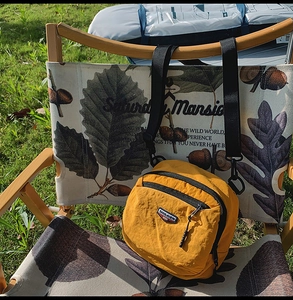 Dettaglio della borsa a tracolla in nylon giallo brillante con logo in un esterno