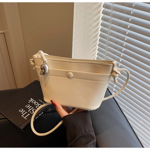 Détail du sac en cuir grainé blanc avec pendentif décoratif en forme de haricot argenté