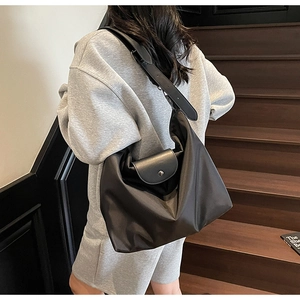 Detail of high-density black nylon tote bag with premium leather flap and strap details