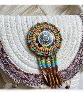 Close-up of bohemian woven bag featuring a mandala ornament and colorful beaded tassels