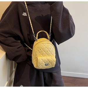 Detailed shot of yellow mini backpack with quilted stitching and silver rhinestone accents