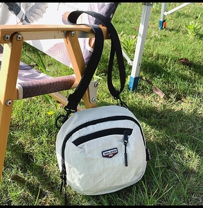 Dettaglio borsa a tracolla in nylon beige con cinturino nero regolabile