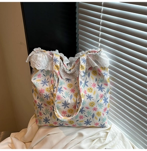 Detailed view of floral canvas tote bag with delicate white lace trim and sturdy handles