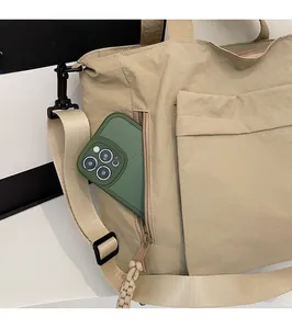 Detail shot of a khaki nylon tote bag featuring a practical side vertical zipper pocket