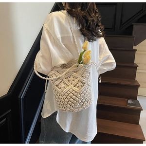 Detail of bohemian ivory cotton rope woven bucket bag with drawstring and fabric lining