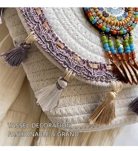 Detail of bohemian straw bag with purple tassels and colorful beaded geometric accents
