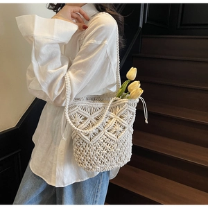 Detail view of the white cotton crochet pattern and drawstring of this woven beach bag