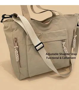 Detailed view of khaki nylon tote bag with adjustable straps and multiple zip pockets
