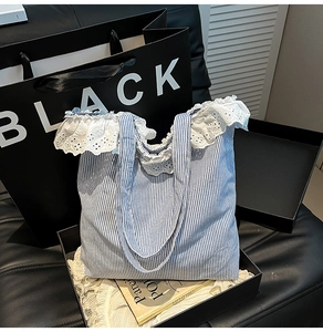 Close-up of blue and white striped canvas tote bag with elegant white lace trim details