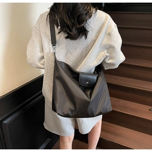 Detail view of a large brown nylon crossbody tote bag with a wide adjustable shoulder strap