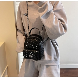 Close-up of quilted chain backpack with pearl details and silver metallic hardware