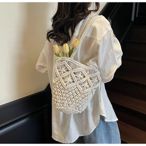 Detail of white macrame shoulder bag with hollow woven pattern and cotton rope texture