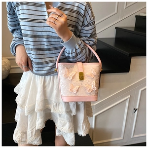 Détail du sac seau en dentelle rose avec papillons 3D et fermoir en métal doré