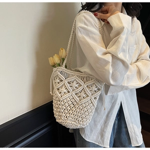 Detailed close-up of handmade bohemian woven cotton shoulder bag with hollow mesh pattern