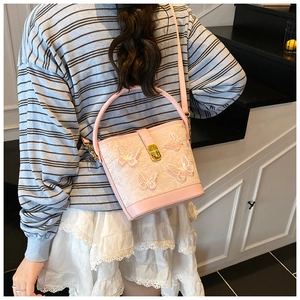Vue arrière détaillée d'un sac seau rose avec papillons 3D et broderies sur modèle