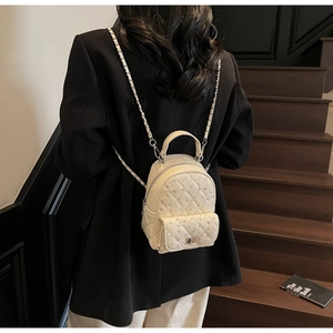 Chic mini quilted backpack with rhinestones and silver chain straps shown on a model