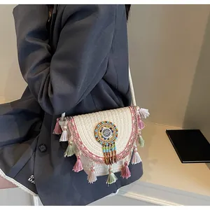 Detail of bohemian woven crossbody bag with colorful tassels and beaded dreamcatcher decor