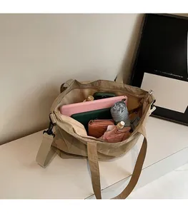 Detail view of khaki nylon tote bag interior with spacious pockets for tablet and wallet