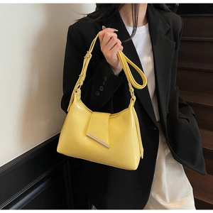 Detailansicht der gelben Lackledertasche mit Goldverschluss und verstellbarem Schultergurt