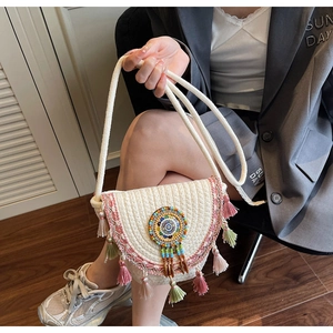 Detail of bohemian woven crossbody bag with colorful beadwork and tassel fringe accents