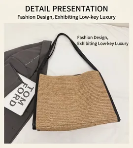 Vue à plat d'un sac à bandoulière en paille tressée beige avec bordure noire sur tissu