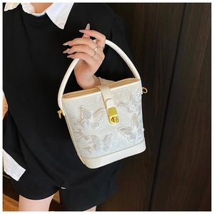 Détail du sac seau blanc avec papillons 3D et fermoir en métal doré de qualité