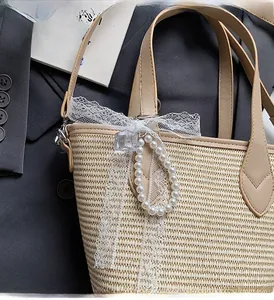 Détail du sac en paille avec nœud en dentelle, breloque perle et anses en cuir