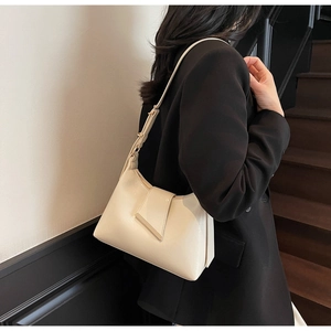 Detail einer minimalistischen creme Hobo-Bag mit verstellbarem Gurt und Metallschnalle