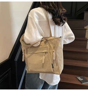 Close-up of khaki nylon tote bag featuring water-resistant fabric and side zipper detail