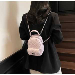 Detail of pink quilted mini backpack with rhinestone studs and silver chain strap