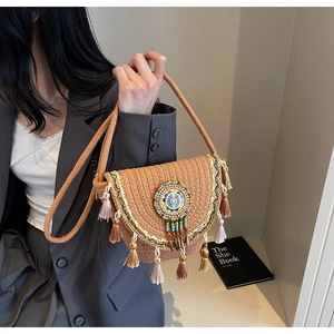 Detail of woven crossbody bag featuring colorful ethnic beads and stylish tassels