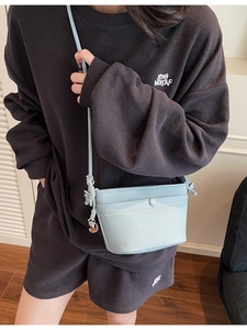 Sac bandoulière minimaliste en cuir bleu clair avec texture litchi et pendentif S