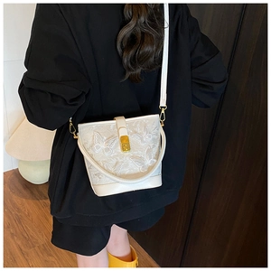 Vue détaillée d'un sac seau blanc avec broderie papillon 3D et boucle métallique