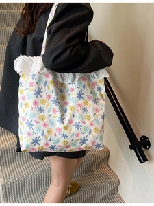 Floral canvas shoulder bag with lace trim and retro aesthetic shown on female model
