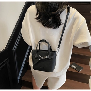 Dettaglio mini borsa a secchiello in pelle nera martellata con fibbia metallica