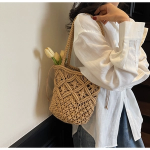 Detail of beige woven cotton shoulder bag with hollow mesh texture and drawstring liner