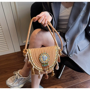 Close-up of bohemian woven shoulder bag with colorful beads and tassel fringe details