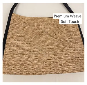 Détail du sac cabas en paille tissée avec anse en cuir noir et motif chevrons