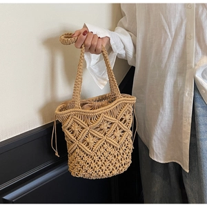 Detail of hand-woven cotton shoulder bag showing hollow knit patterns and drawstring liner