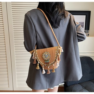 Detail of bohemian woven shoulder bag featuring colorful beads and long tassel accents