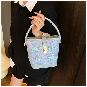 Détail du sac seau bleu clair avec appliques papillons 3D et texture dentelle