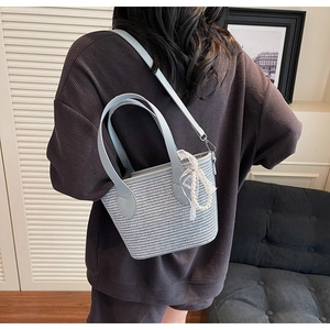 Détail du sac à main tissé bleu clair avec pendentif en perles et dentelle élégante